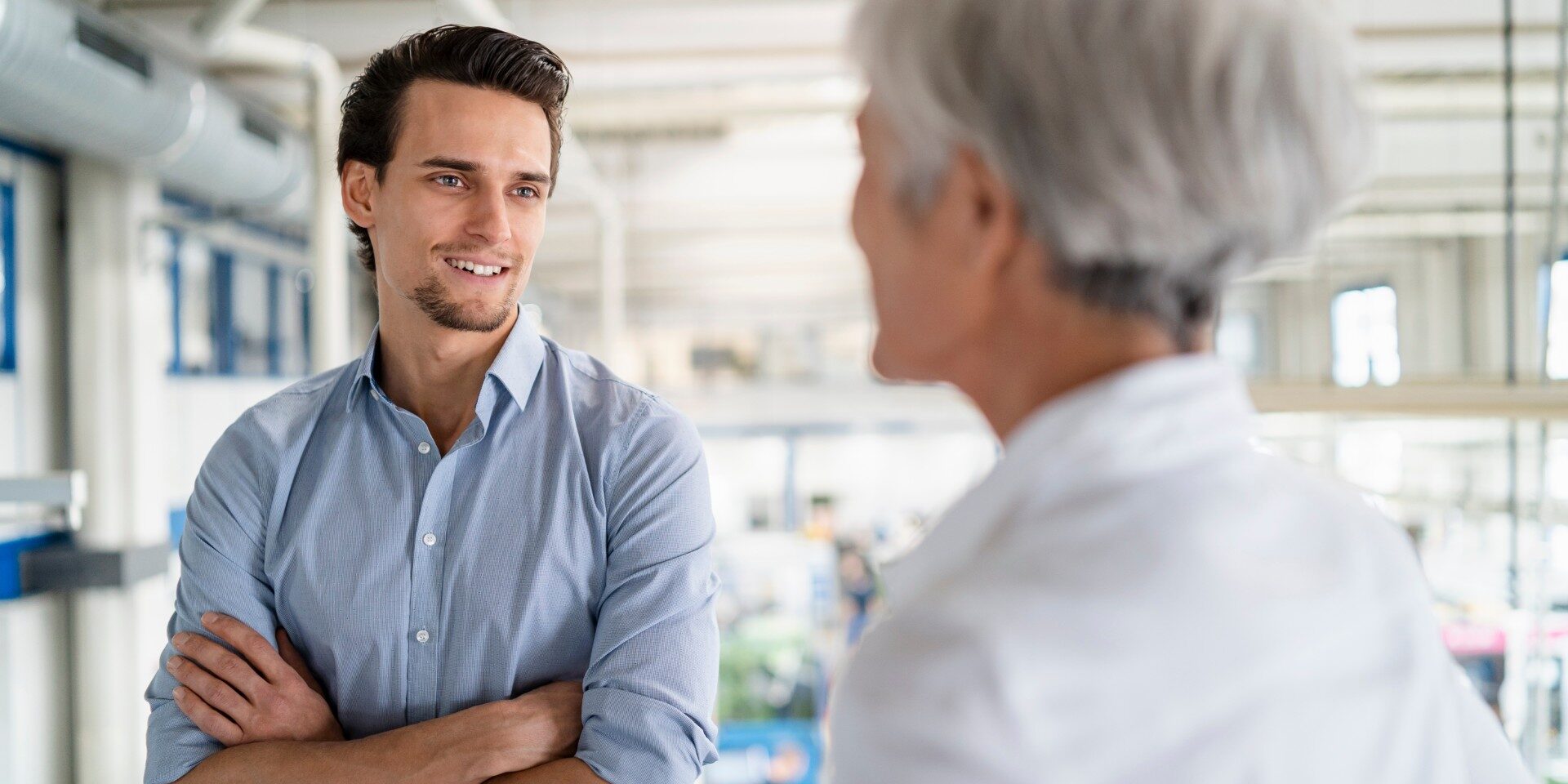 Smiling businessman talking to senior businesswoman in a factory Smiling businessman talking to senior businesswoman in a factory